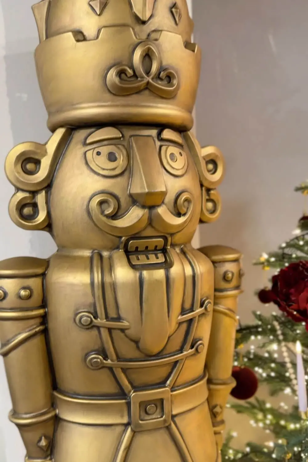 Close up of an antique bronze giant nutcracker showing the black patina detail in the grooves and trim to mimic aged metal.