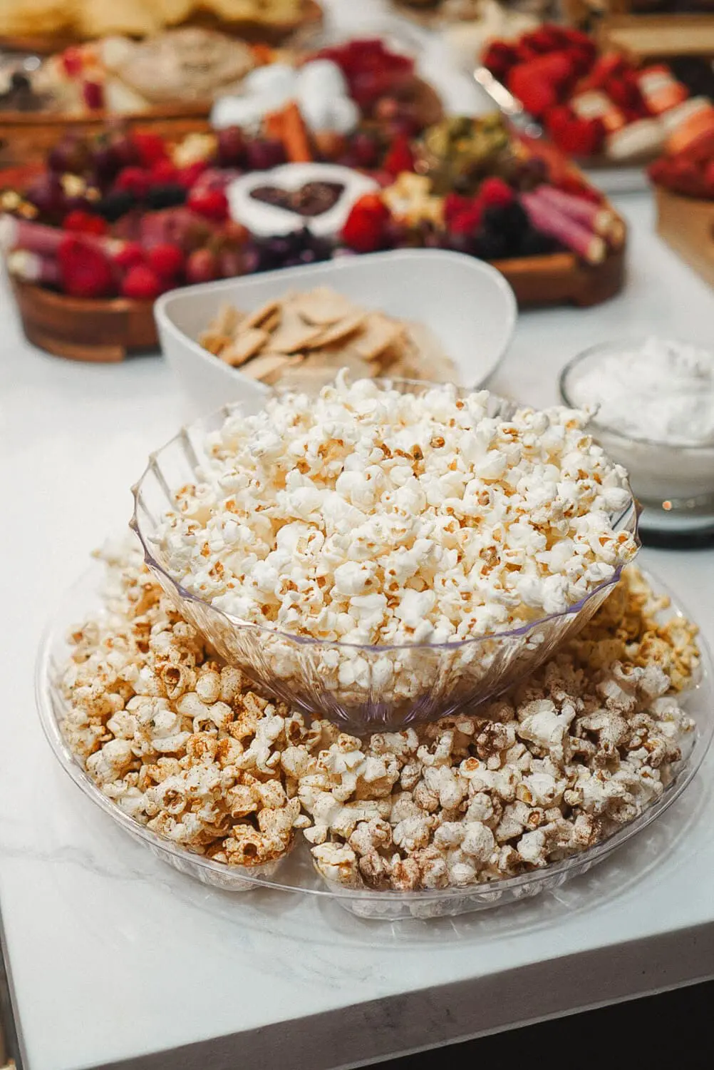 Popcorn trio snack in a tiered display. Perfect for a festive gathering, featuring bowls of classic buttered popcorn, kettle corn, and cinnamon-sugar popcorn.