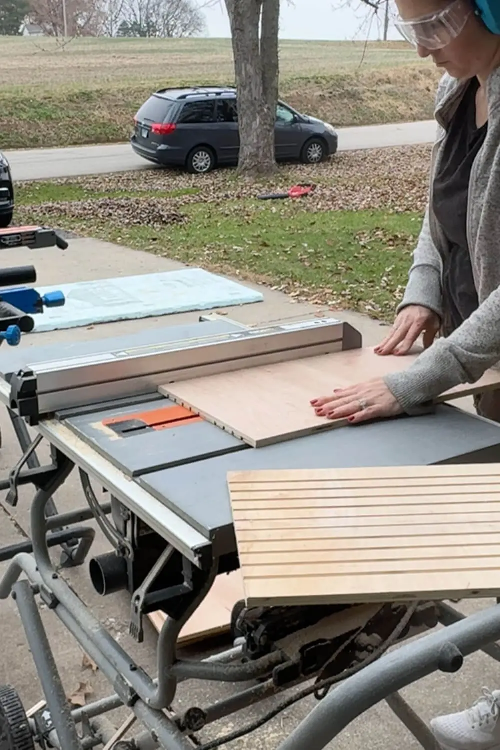 Woman using a table saw to cut grooved plywood slats for a DIY sheet pan organizer cabinet