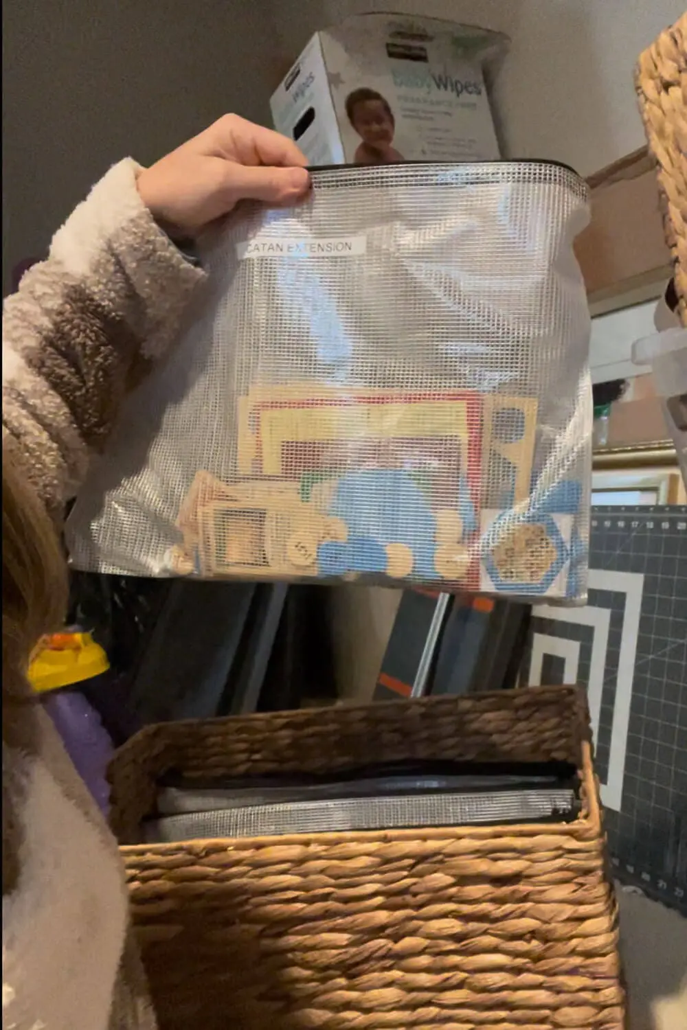 Board Game Storage Ideas using a labeled mesh zipper bag to store a board game expansion with all the pieces together, so it fits neatly in a basket instead of a bulky box.