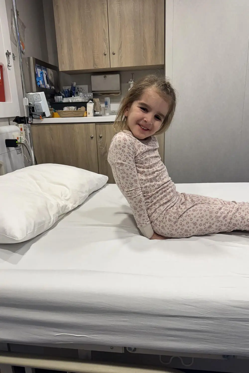 Young child sitting on an exam bed inside the ship's medical center, showing a real-life moment when you need onboard medical care during a family vacation.