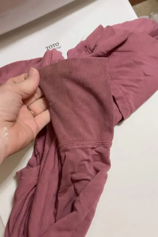 Close-up of a grimy kids sweatshirt sleeve showing heavy detergent buildup before deep cleaning to remove gross residue and trapped odors.