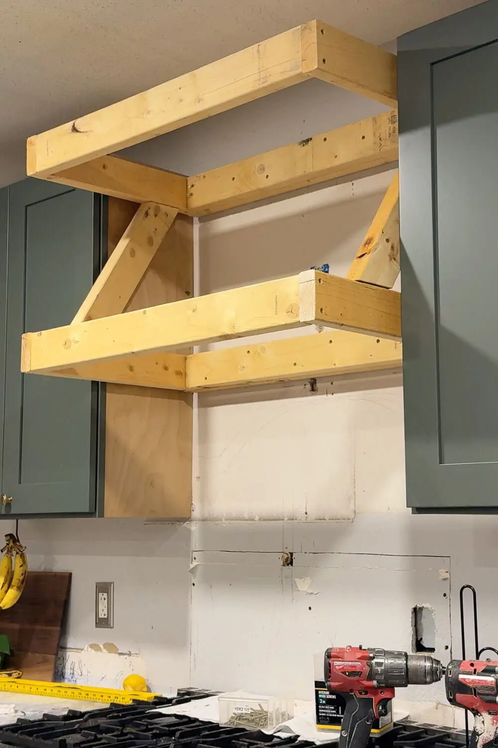 DIY range hood cover frame with angled support braces installed on both sides for added strength and rigidity.