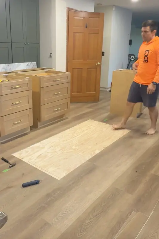 Removing flooring to to make way for a kitchen island to be installed directly to the subfloor.