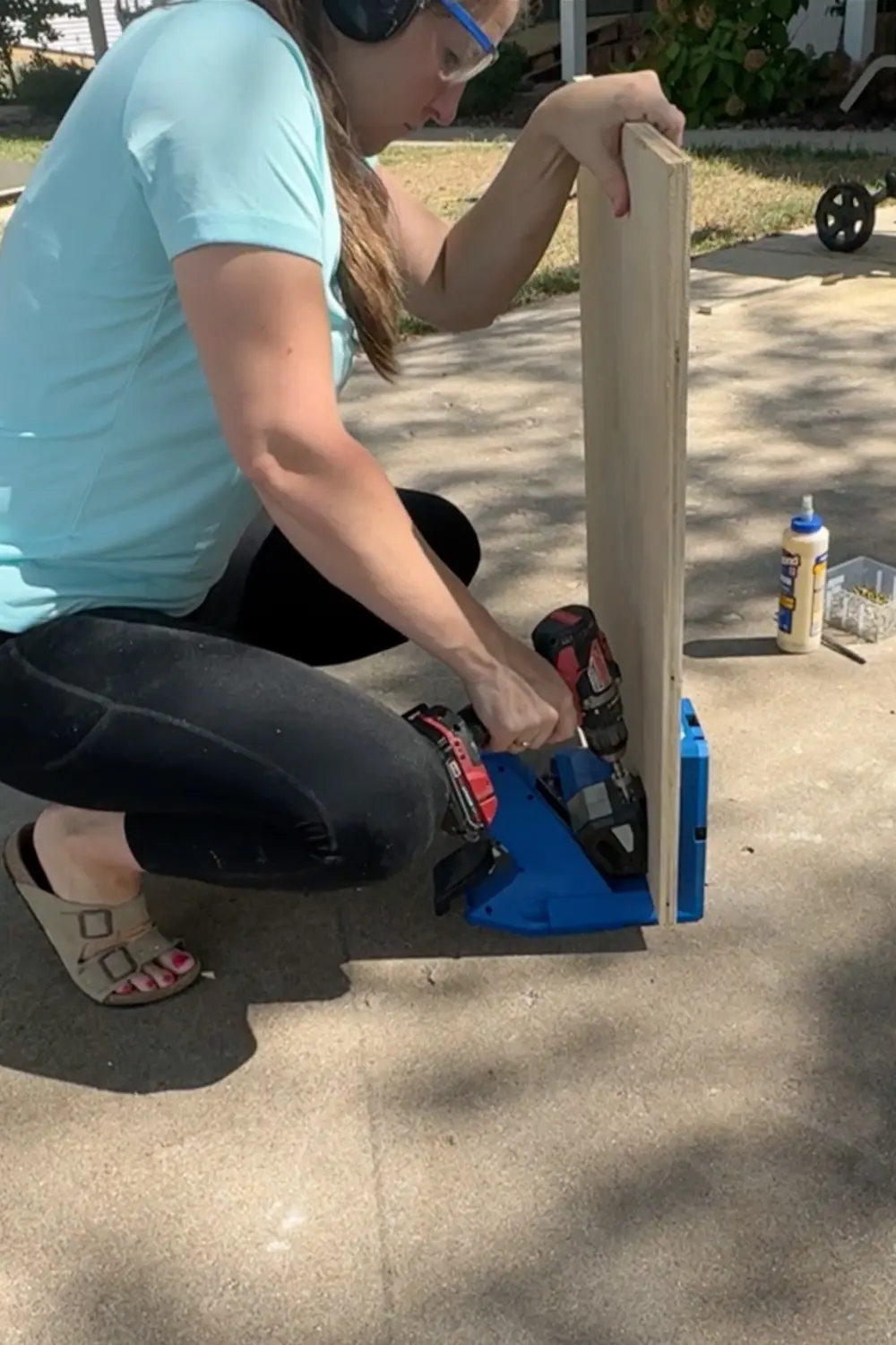 Using a Kreg pocket hole jig and drill to make pocket holes in plywood, prepping boards for assembling our DIY built-in bookshelves for a cozy home library.