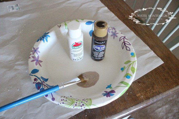 Brown paint on a paper plate with a paint brush