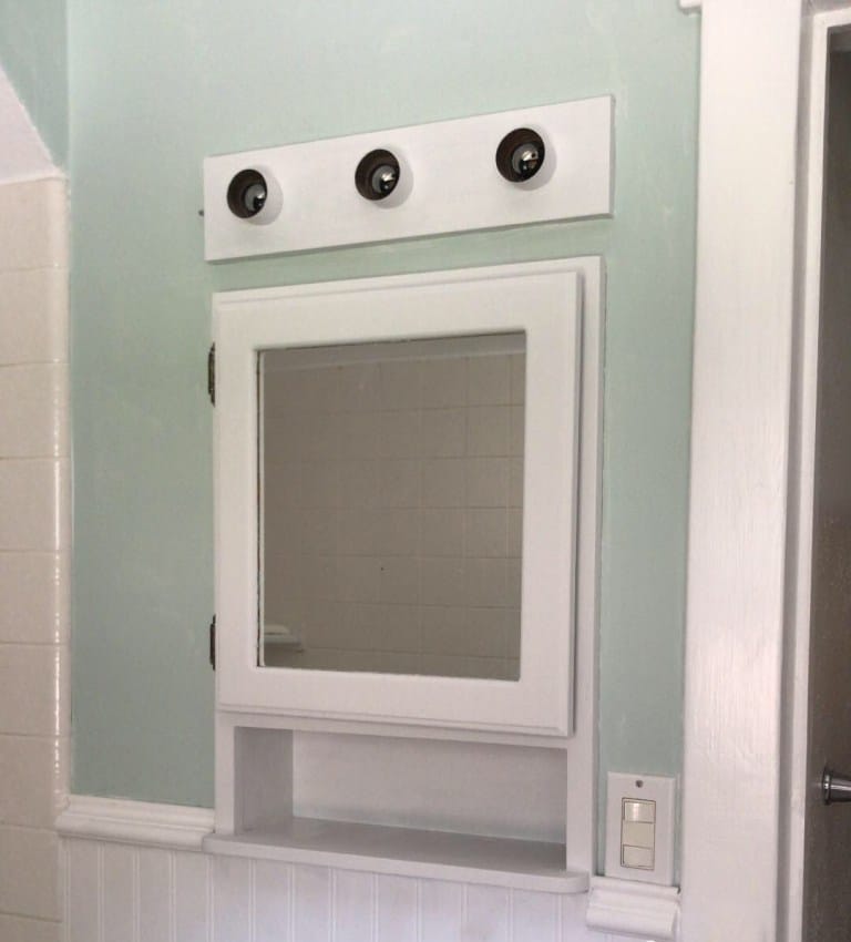 White medicine cabinet and green walls
