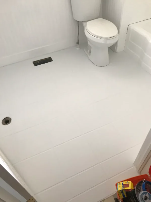 two coats of white paint on bathroom tile floor