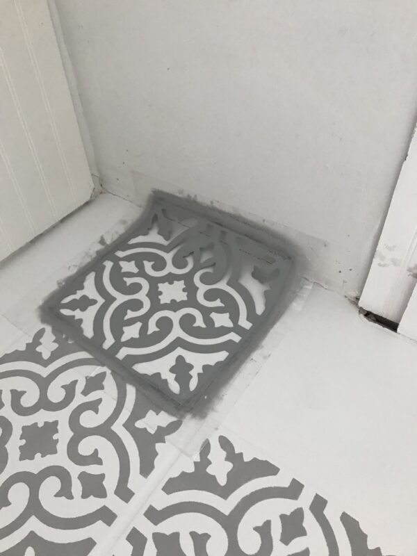 stencil up against wall on tile floor