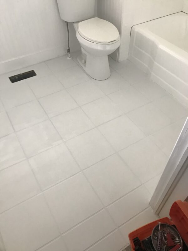 Painted white tile floor in bathroom with one coat