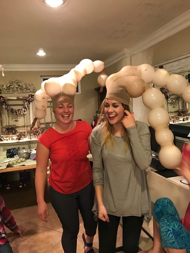 Two women with balloons in pantyhose on their heads