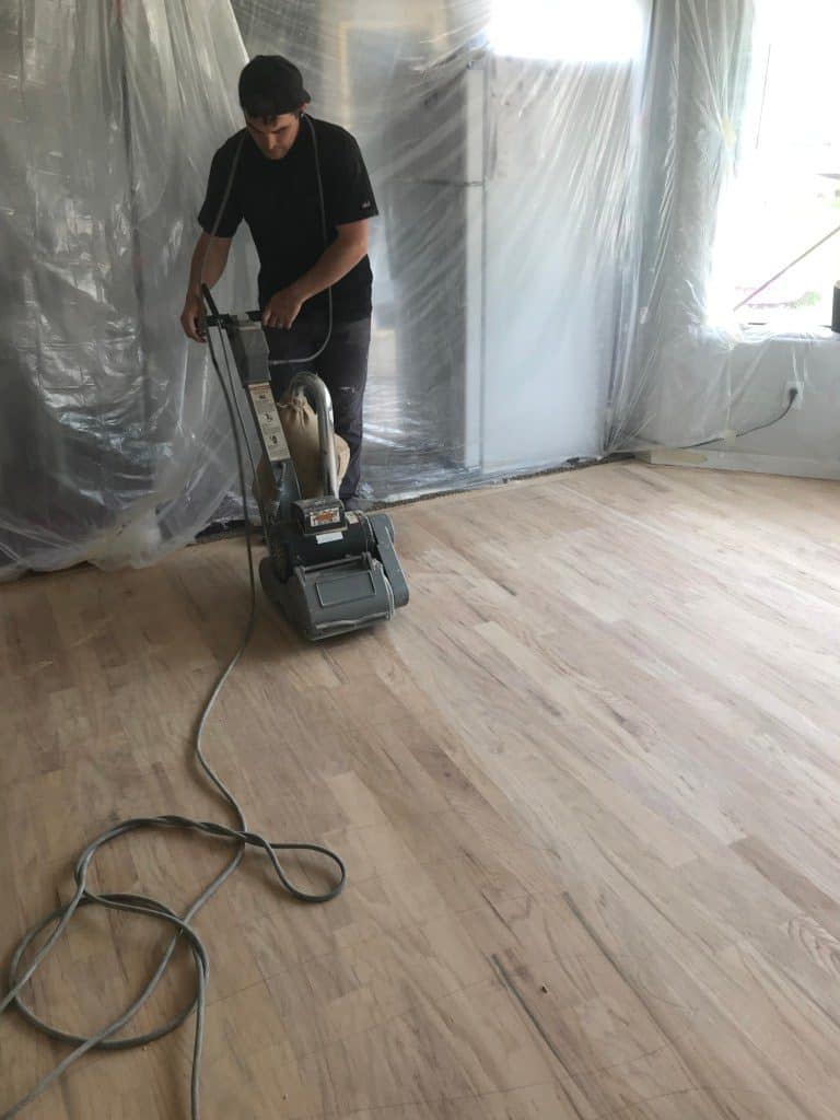 Man sanding a wood floor