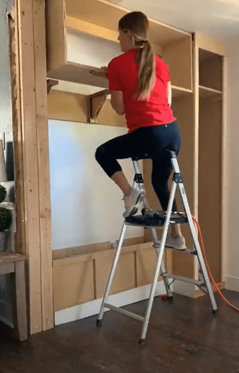 Woman on ladder building a storage room