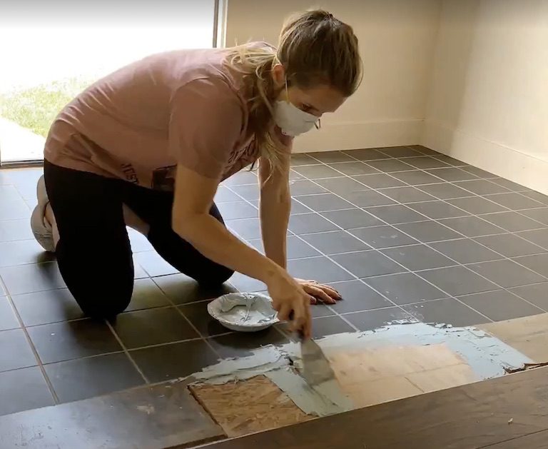 woman using bondo on floor