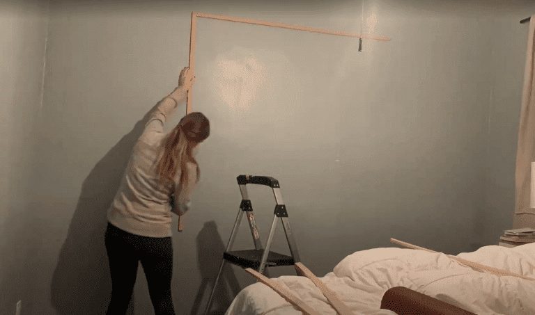 woman putting wainscoting on a wall 