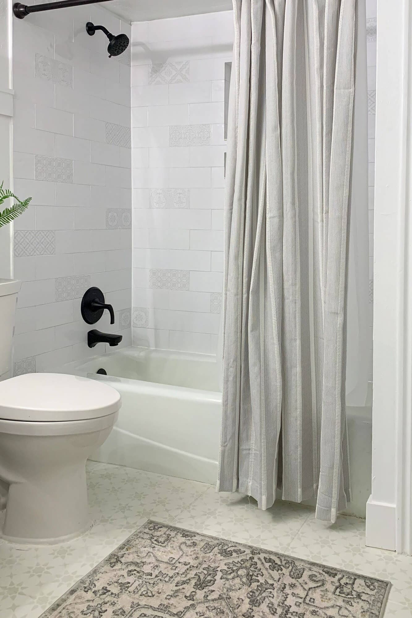how to get rid of mold in a shower: Finished bathroom with white tile tub surround, black fixtures