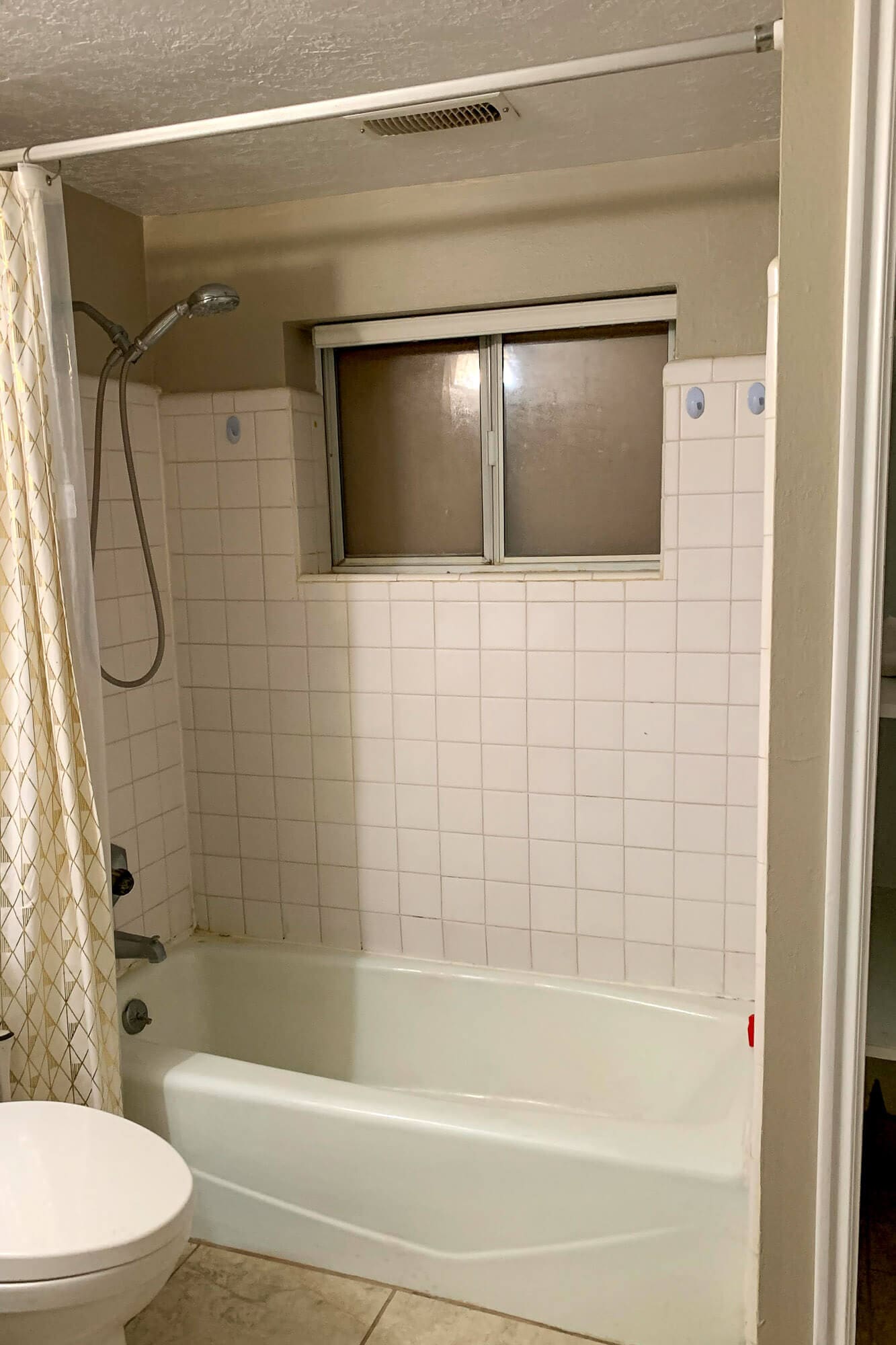 before photo—stained tile and failing grout leading to mold in shower