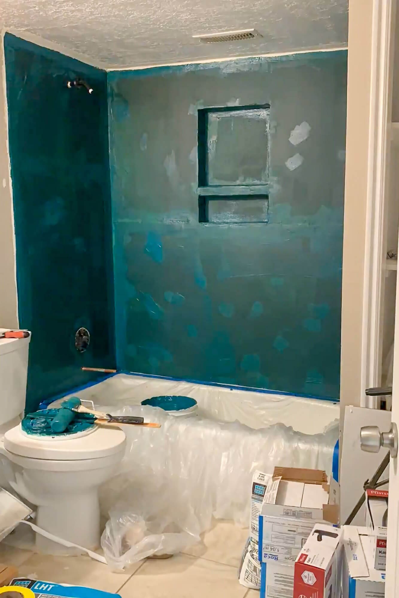 How to get rid of mold in a shower—shower mold removal progress with waterproofing membrane painted over cement board and niche before tiling.