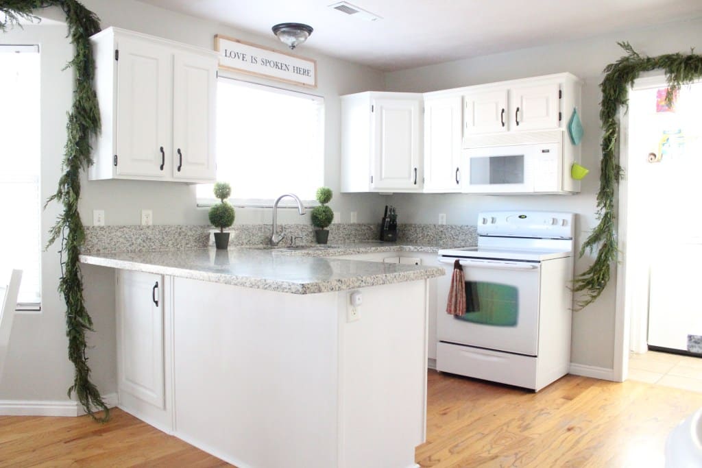 Kitchen with white cabinets and garland