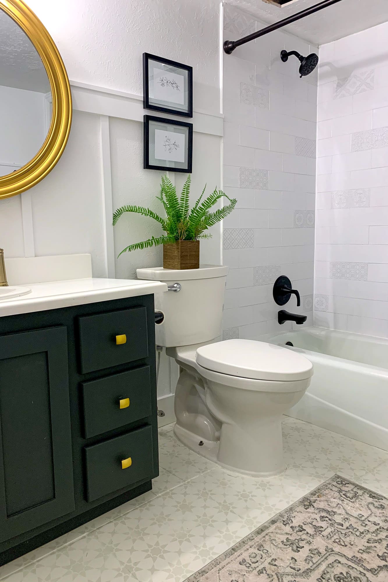Bathtub shower with white tile, black fixtures, and patterned curtain.