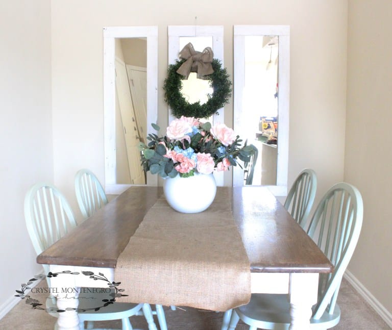 Mirrors and a kitchen table with flowers on top