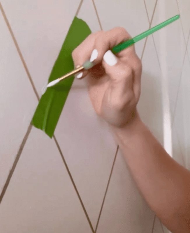 Woman painting bathroom wall white