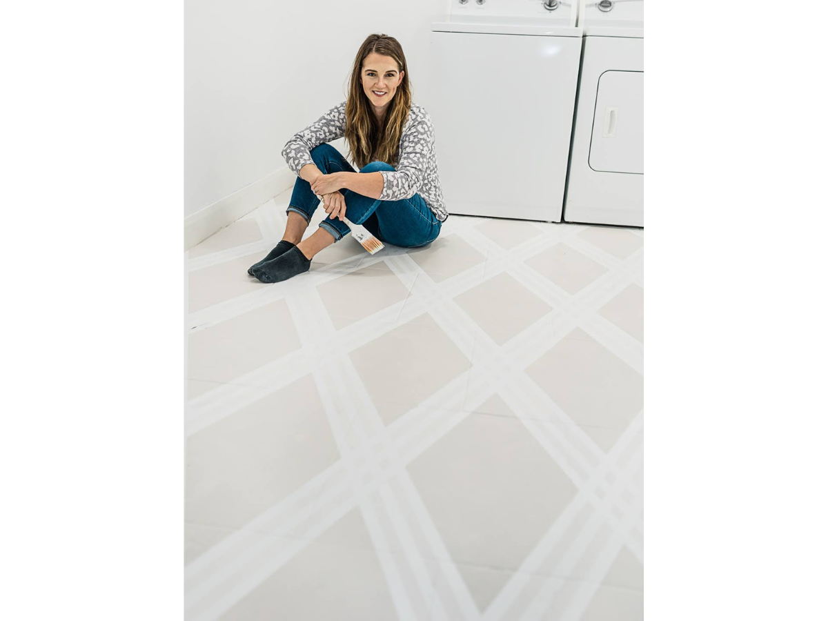 Woman sitting on painted tile floor