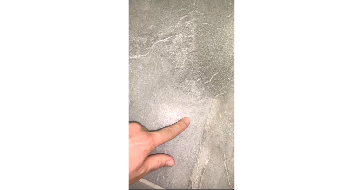 Finger pointing to grey tile