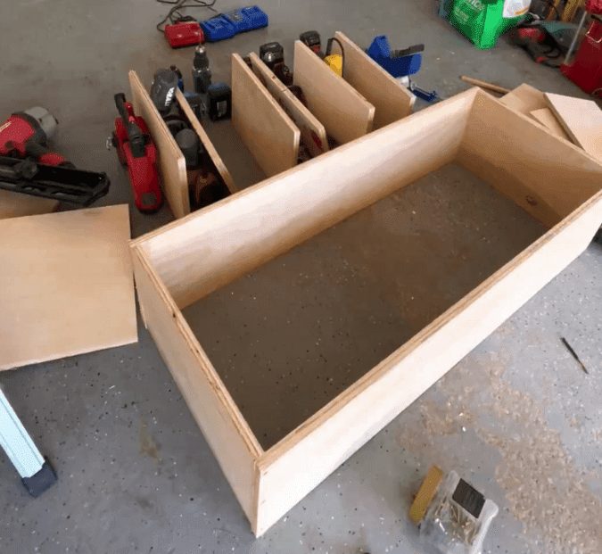 A box made out of wood laying on a garage floor