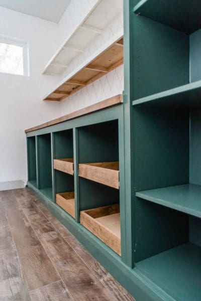 green butler's pantry cabinet with two pine sliding drawers in each lower cubby