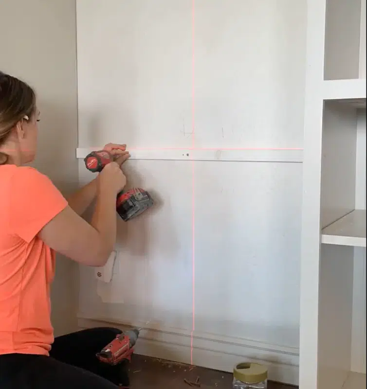woman drilling into wall