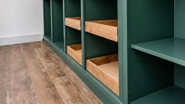 four pine sliding drawers in the cubbies of a green butler's pantry cabinet