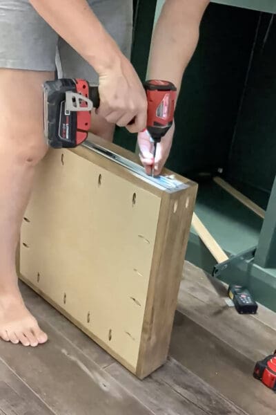 drilling a screw through a drawer slide into the side of a drawer box