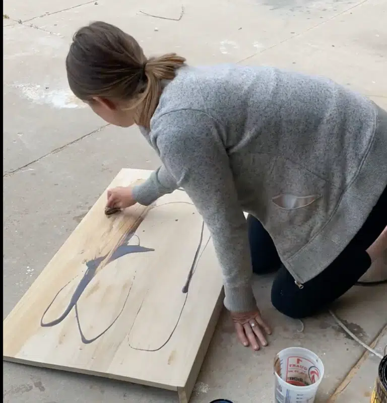 woman staining a desk