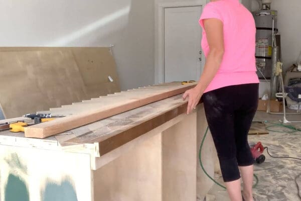 2x4 guide clamped along the front edge of the herringbone countertop