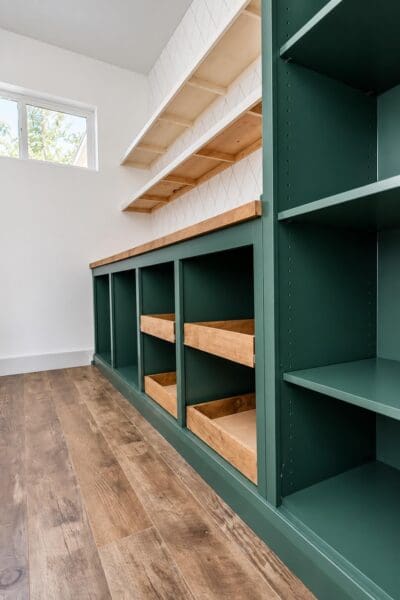 green butler's pantry with sliding drawers and floating shelves before the undersides were painted