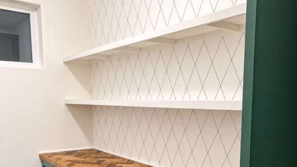 white DIY floating pantry shelves above a herringbone counter with a diamond Sharpie wall