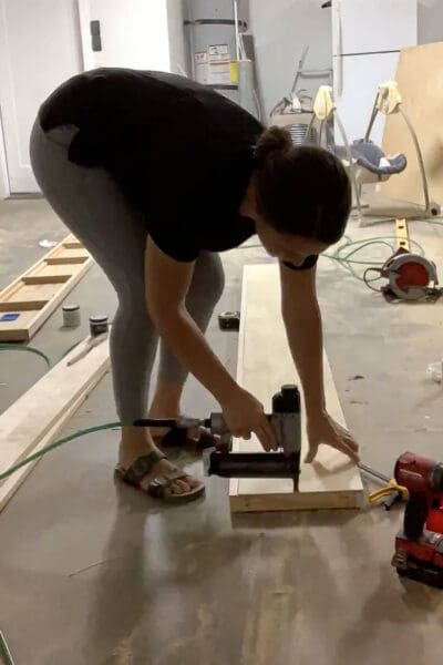 Crystel brad nailing the plywood top onto a floating shelf frame