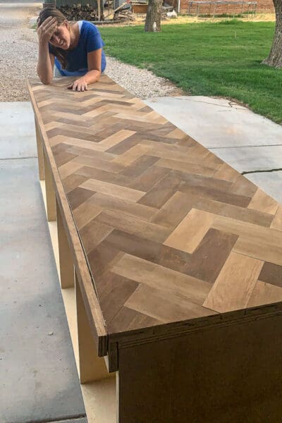 Crystel leaning on the herringbone countertop after a crooked first cut