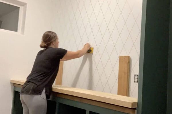 Crystel marking a stud on the pantry wall for shelves