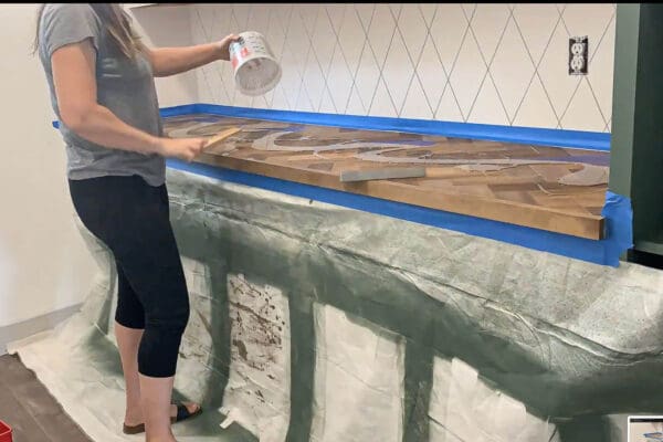 pouring epoxy onto the herringbone countertop over plastic drop cloths