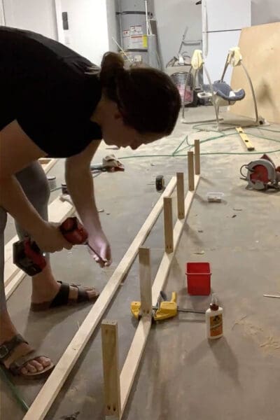 Crystel screwing 1x2 supports to the cleat of a floating shelf frame