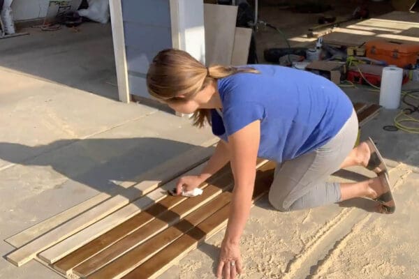 Crystel wiping stain onto plywood strips for a herringbone countertop