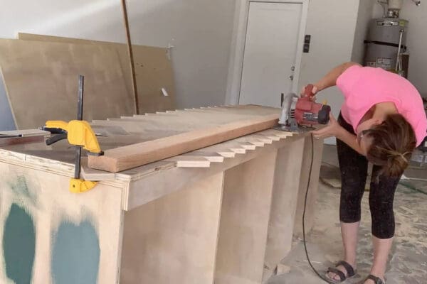 trimming the herringbone countertop with a circular saw against a clamped 2x4 guide