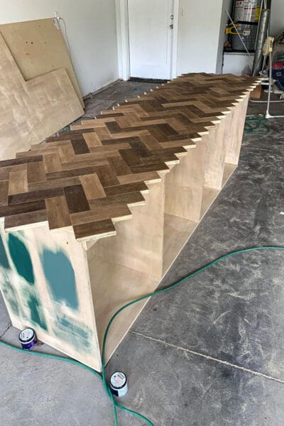 wood herringbone pattern with the board ends running past the cabinet edge before trimming