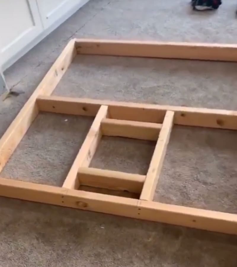 2x4 stud frame with recessed media box opening laid flat on garage floor before installation
