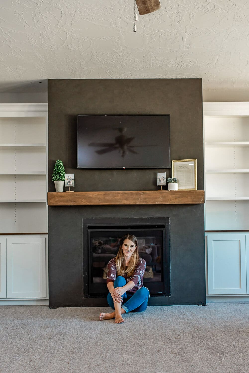 DIY floating fireplace mantel made from pine boards installed above black Roman Clay fireplace