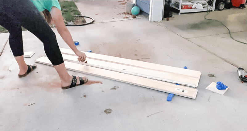 woman using wood glue for a floating beam mantel