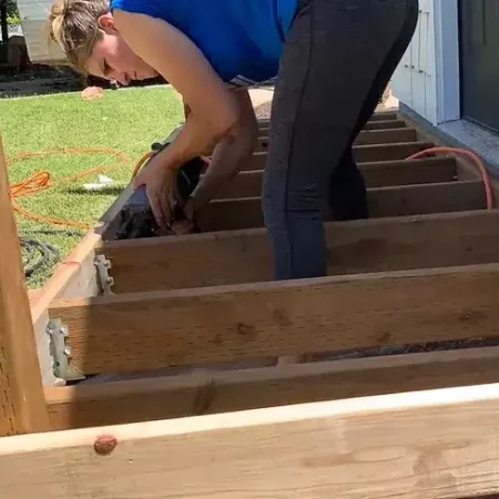 woman nailing joists for a small front porch