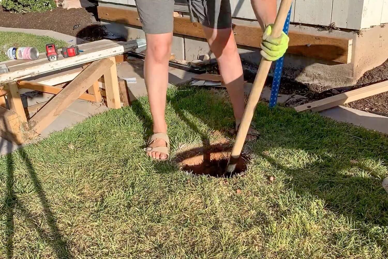 Crystel digging a post hole with a post-hole digger inside the spray-painted circle.
